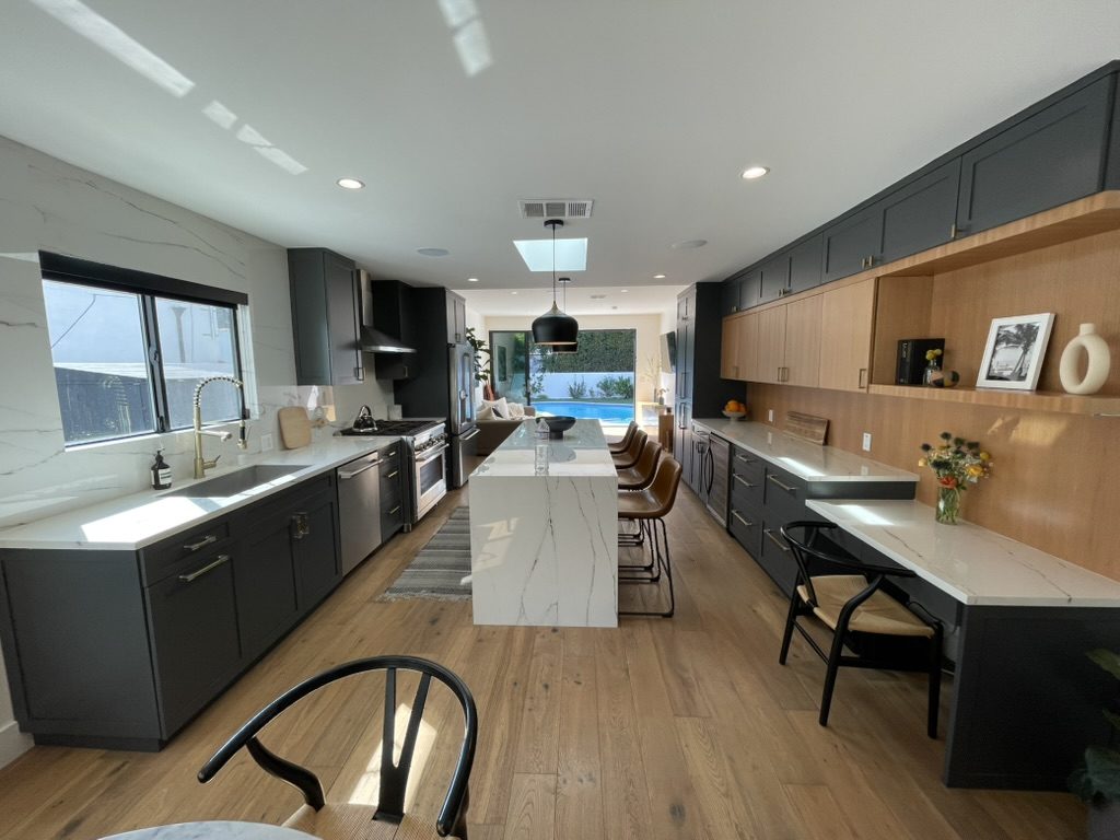 After: open kitchen with white island, integrated appliances and oak floors