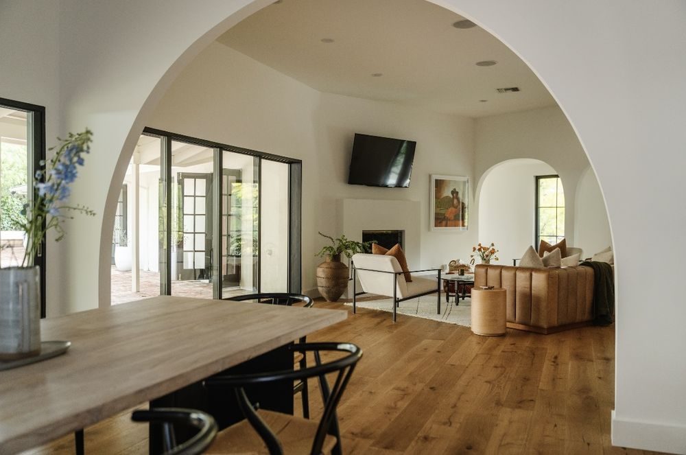 Renovated living room with plaster archway, oak floors and steel-framed doors to the garden