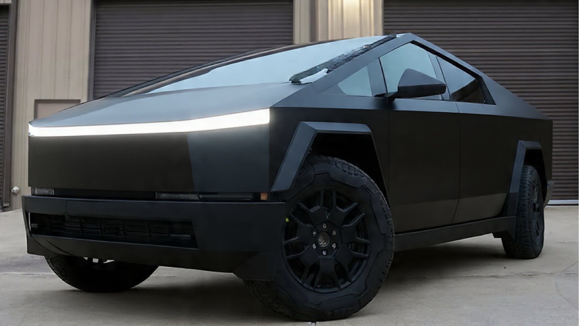 Matte-black Tesla Cybertruck after ceramic coating, full view, parked outside the shop bays