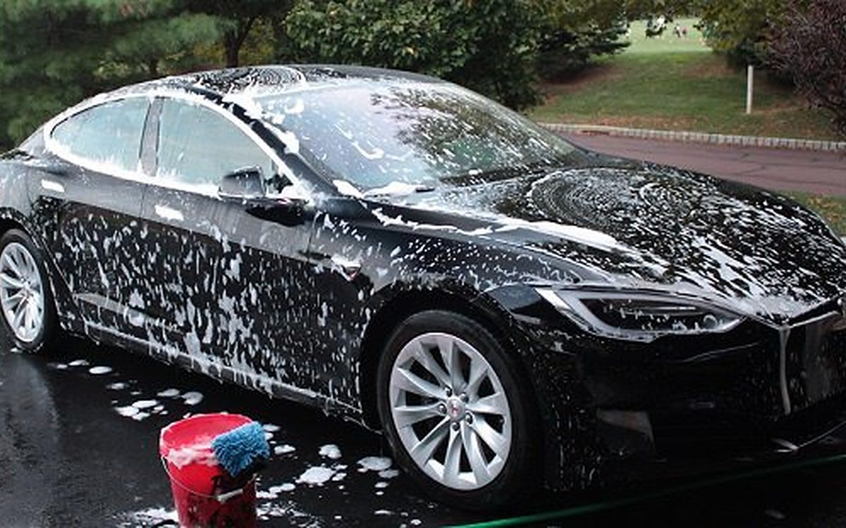 Black Tesla Model S covered in foam during the spot-free foam bath of a Signature Full Auto Detail