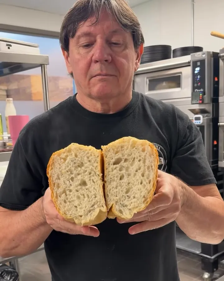 Claudio Alicandri breaking open a fresh loaf in the Italizzia kitchen