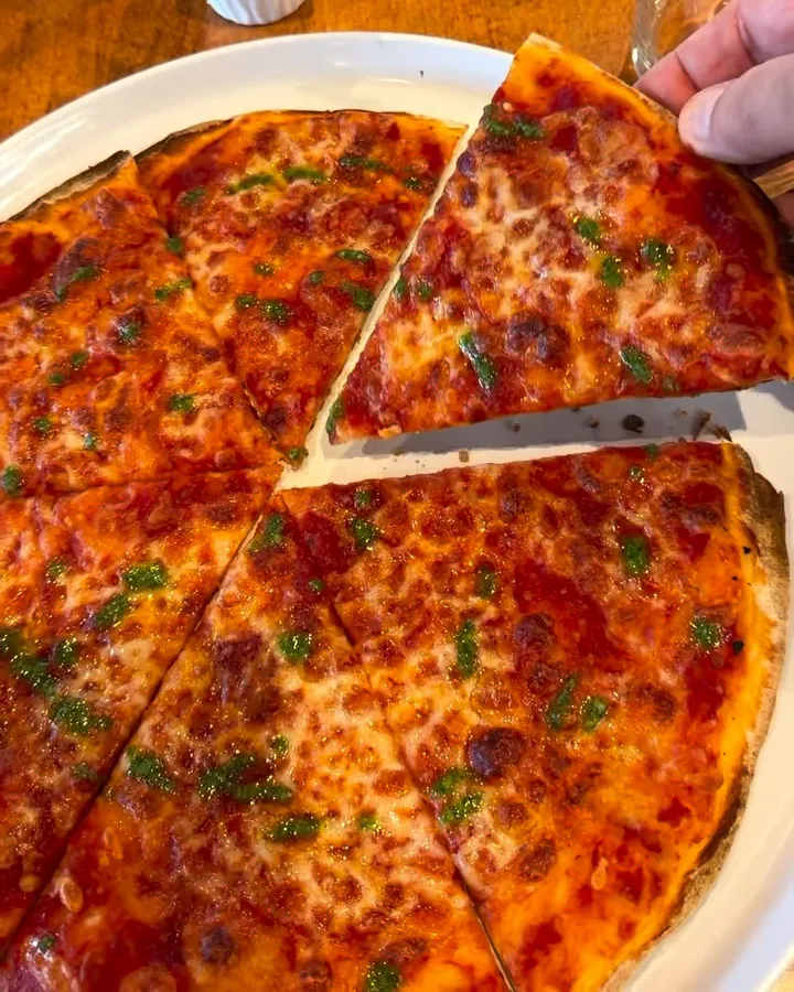 Thin, crisp Roman-style pizza made on an Italizzia base, sliced on a white plate