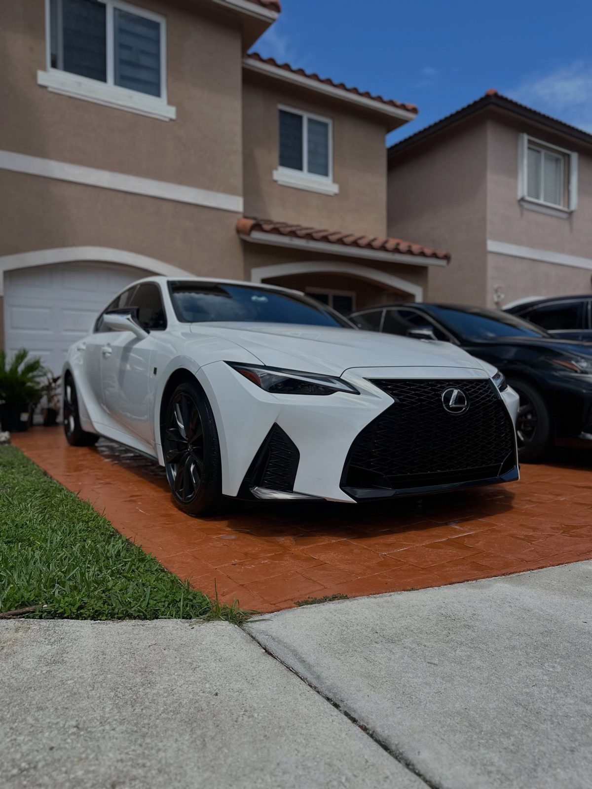 White Lexus IS on a red driveway after detailing