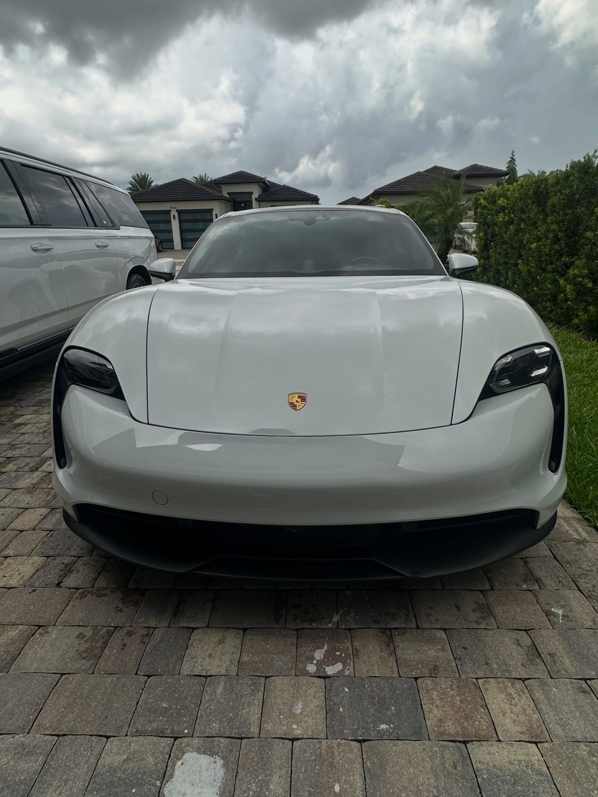 White Porsche Taycan detailed on a paver driveway
