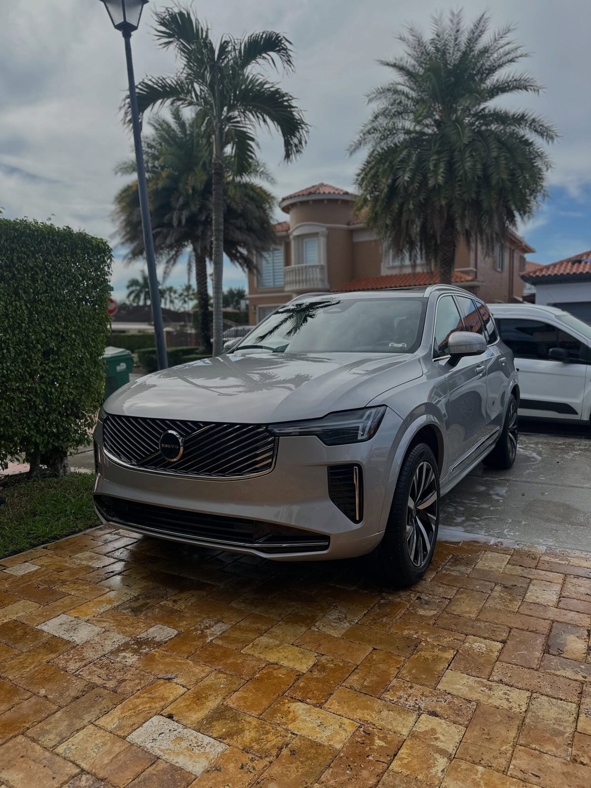 Volvo SUV freshly washed on a wet paver driveway