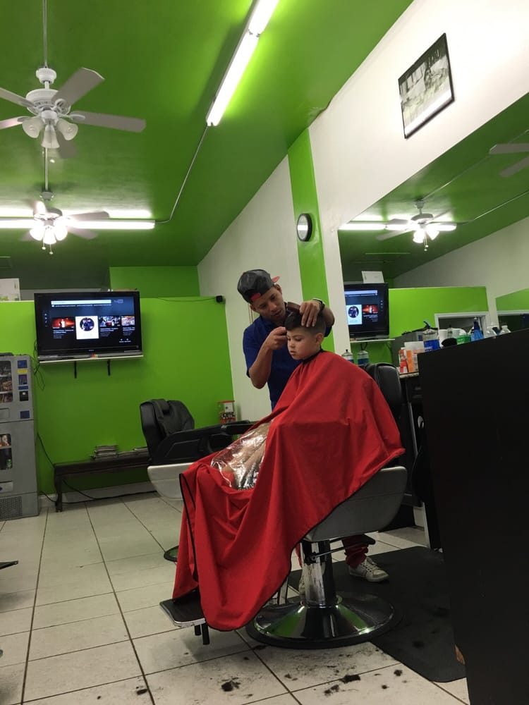Inside Maikel Barber Star: red chairs and green walls