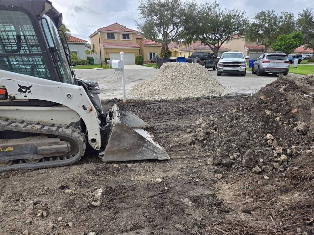 Bobcat spreading and grading dirt on a residential lot