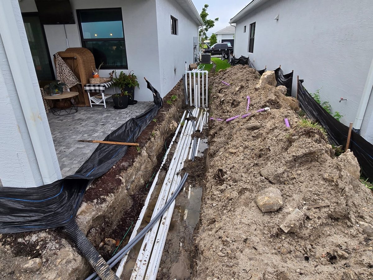 Trench backfill along a house after plumbing work