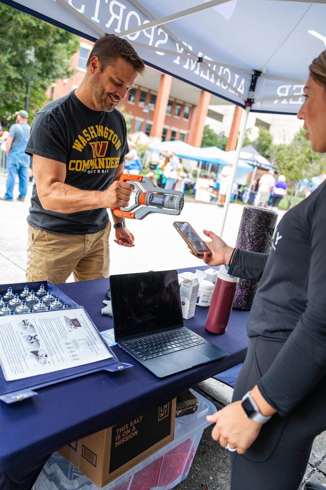 Vendor talking with a visitor at a booth table