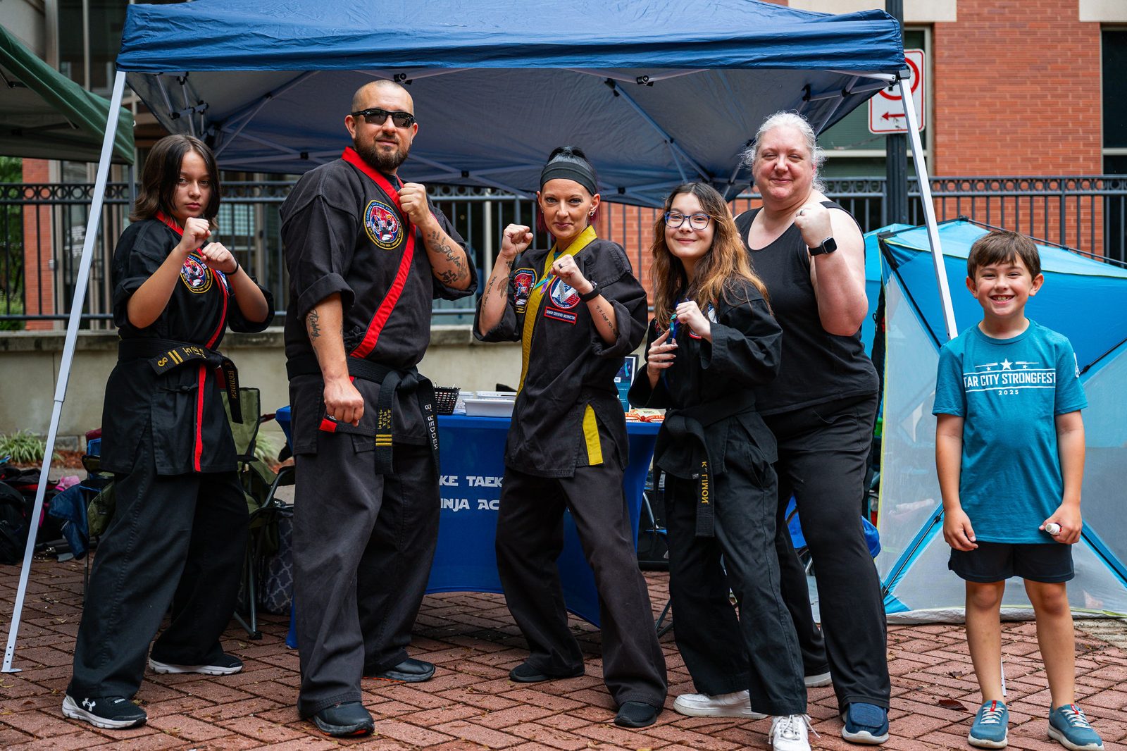 Martial arts academy team posing under their vendor tent