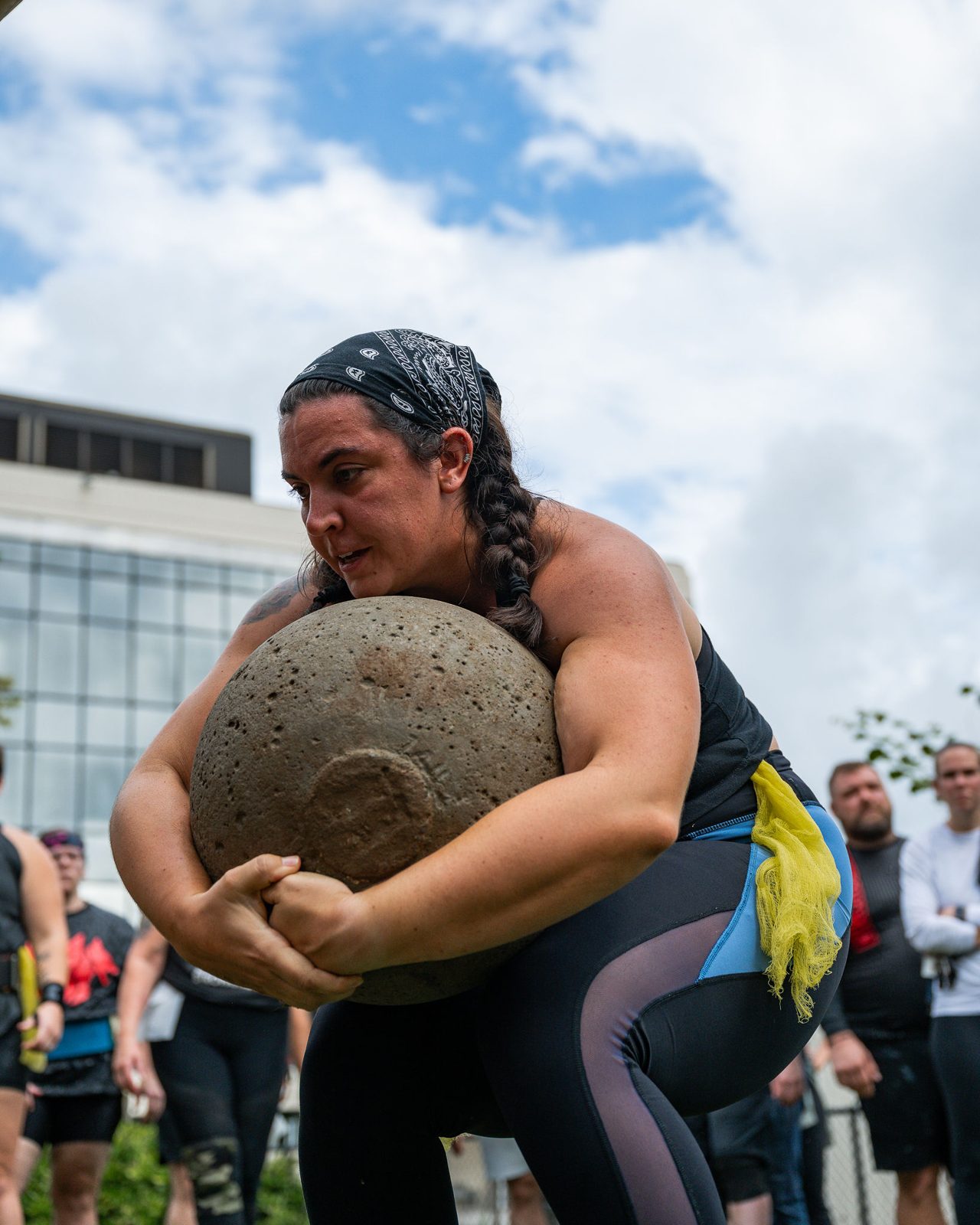 Female athlete shouldering a natural stone at Star City Strongman