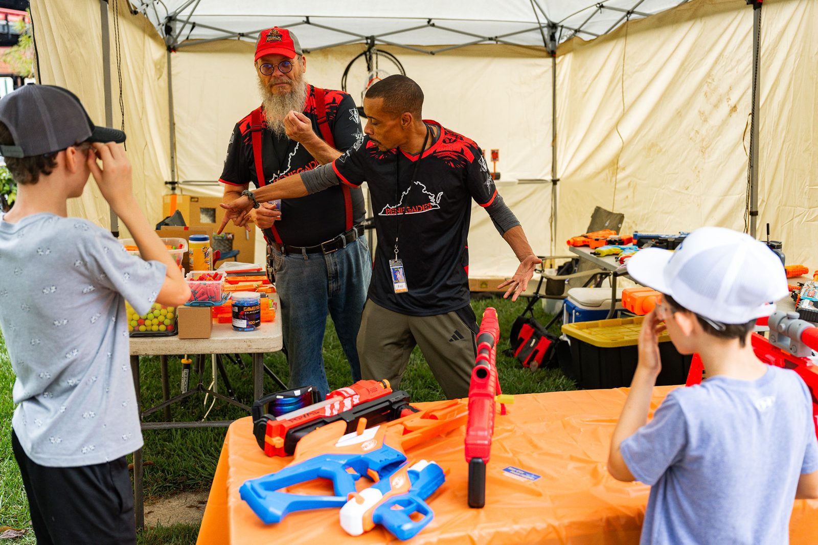 Kids playing a foam blaster game at a vendor booth