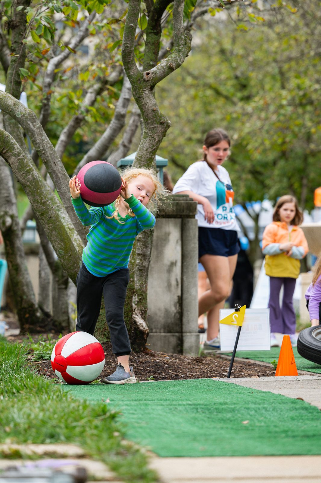 Kids playing with a ball on the turf in the Kidz Zone