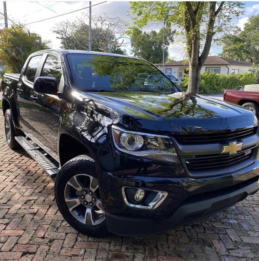 Black Chevy Colorado detailed on a paver driveway