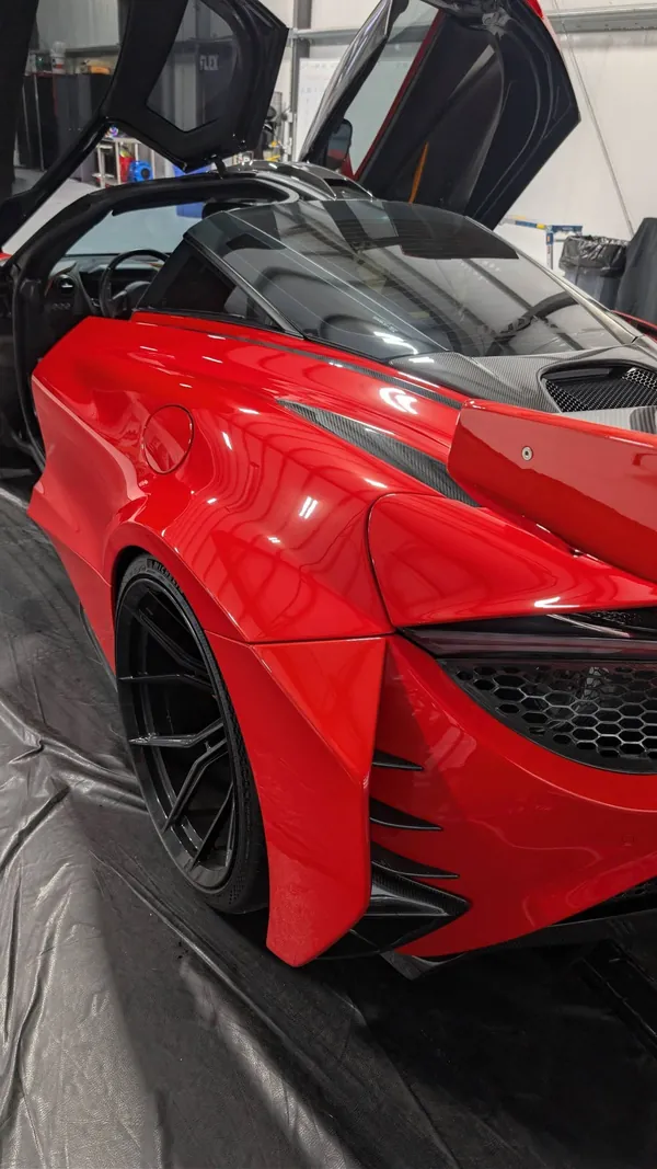 McLaren 720S rojo con las puertas arriba en el taller