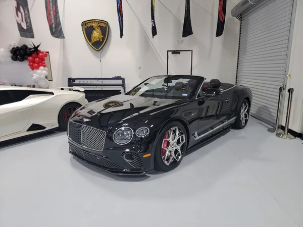 Bentley convertible negro en el showroom con globos