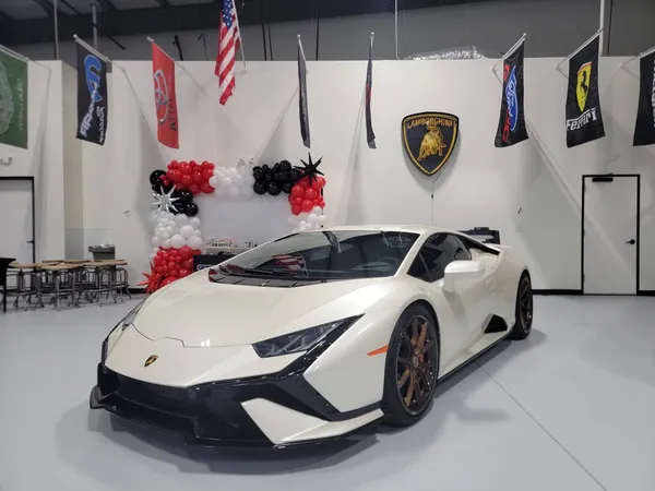 Lamborghini Huracán blanco en el showroom con globos y banderas