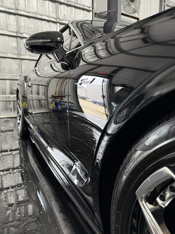Reflejos profundos en el costado de un carro negro