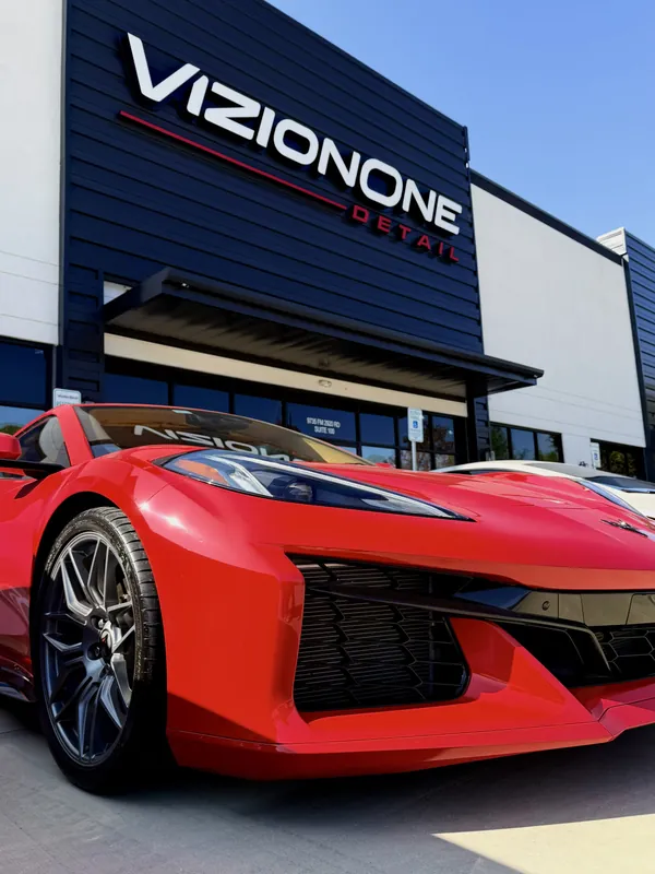 Corvette Z06 rojo bajo el letrero de VizionOne
