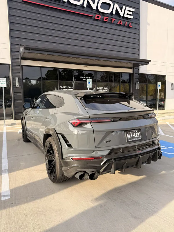 Lamborghini Urus gris frente al local