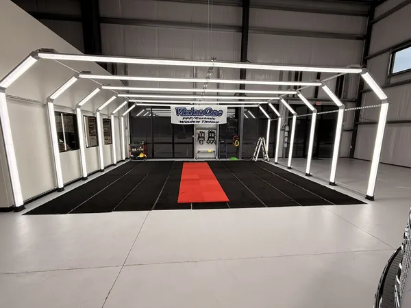 El túnel de luces encendido sobre el piso negro y la alfombra roja