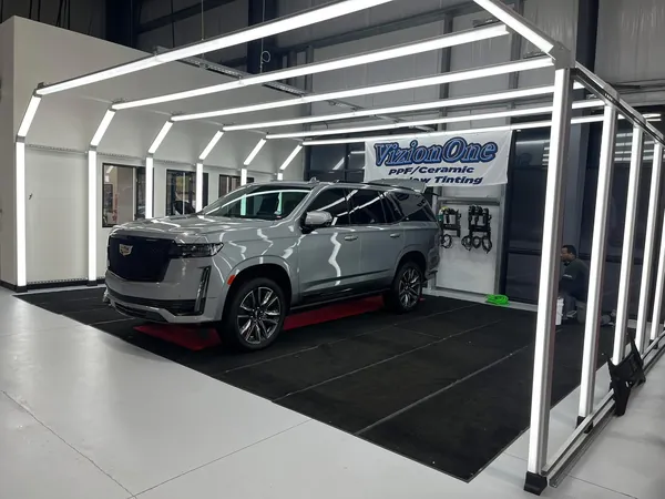 Cadillac Escalade plateada bajo el túnel de luces