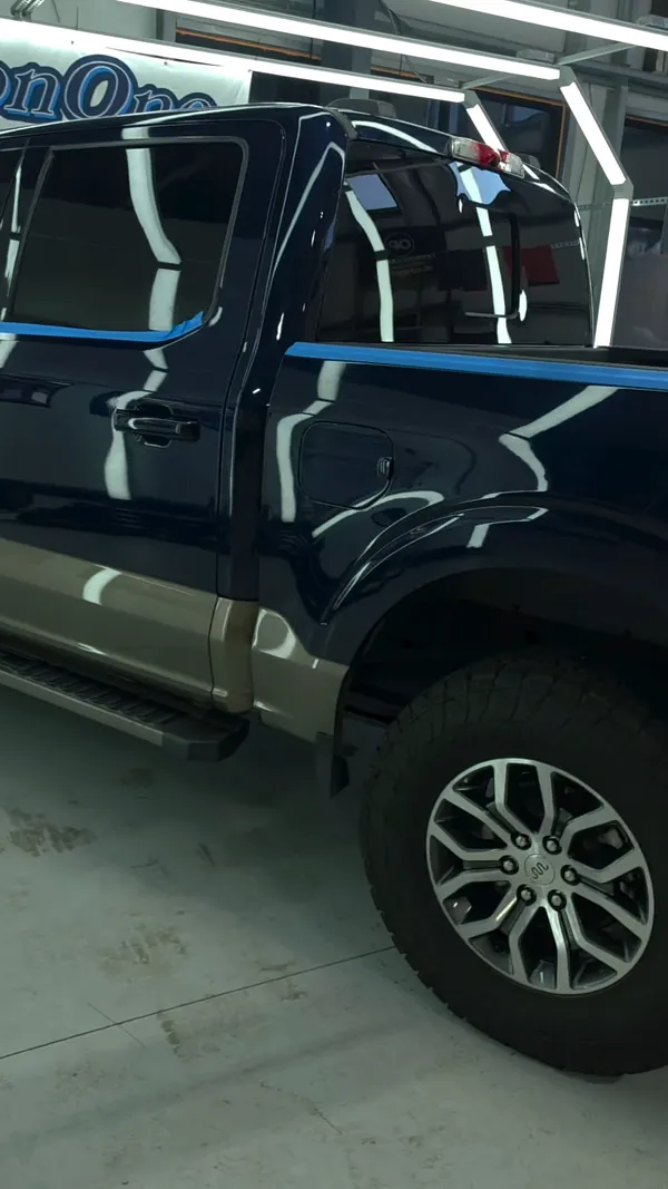 Ford F-150 azul con cinta bajo el túnel de luces