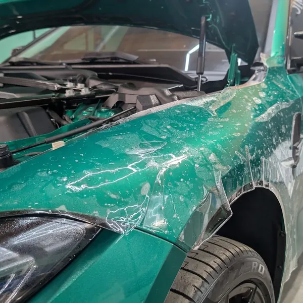 Película de protección mojada colocándose en un carro verde