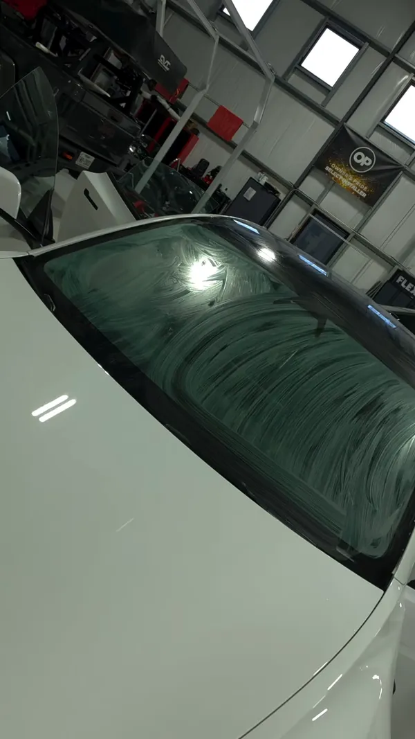 Película de polarizado acomodándose en el parabrisas de un Tesla blanco