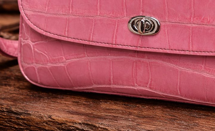 Macro view of the hand-stitched flap edge of the Rosé Alligator Shoulder Bag